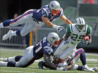 The Patriots flew over the Jets 38-14 in the regular season opener. Here Jets running back Leon Washington (29) is brought down by the Patriots Jarvis Green (97) and high flying New England linebacker Tedy Bruschi (54).