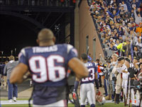 Patriots head coach Bill Belichick (left) gets a hand from the fans as he and his players, including Adalius Thomas (96), leave the field following New England's Week 2 victory.