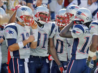 After Patriots wide receiver Randy Moss (81, second from left) caught a fourth quarter 45 yard touchdown pass from quarterback Tom Brady (12, left) (his second of the game), they and other teammates celebrate the play.