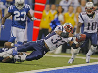 Patriots running back Kevin Faulk leaps into the end zone with the game winning touchdown as he scores on a 13 yard fourth quarter pass from Tom Brady, with Colts linebacker Gary Brackett hanging on to him.