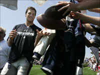 Tom Brady (12) was airborne as he pumped his fist next to Chargers linebacker Shawne Merriman (56) following the first New England tocuhdown of the game.
