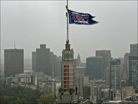   Workers hang the AL Championship pennant from the top of the John Hancock tower.  (David L. Ryan/Globe Staff)