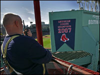   Michael Patti watches the AL championship pennant get hung up at Fenway Park. (David L. Ryan/Globe Staff)