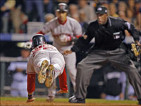   Mike Lowell dives for home plate as Julio Lugo and umpire Chuck Meriweather look on during the fourth inning of Game 4 of the World Series. (Jim Davis/Globe Staff)