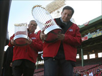   Mayor Tom Menino and Sox chairman Tom Warner carry the 2004 and 2007 World Series Championship trophies at Fenway Park. (Stan Grossfeld/Globe Staff)