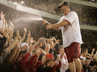   Red Sox catcher Jason Varitek sprays down the fans in an on field celebration. (Barry Chin/Globe Staff)