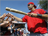 Under deep blue skies with a temperature in the low 80s, Red Sox third baseman Mike Lowell signs some autographs for fans as he comes off the field following a spring training workout. (Jim Davis/Globe Staff)
