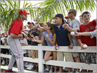 Red Sox catcher and captain Jason Varitek (33) ducks under a palm tree as he signs autographs for a crowd of fans after a spring training workout. (Jim Davis/Globe Staff)