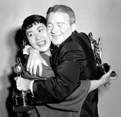 Miyoshi Umeki and Red Buttons hugging after winning best supporting actress and actor for their roles in 'Sayonara.'