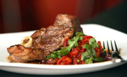Juicy lamb chops are accompanied by a red pepper and arugula salad at Sagra.
