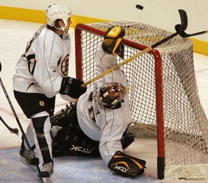 Hockey or Twister? Bruins goalie Mike Brown watches a shot bounce off the crossbar during a scrimmage yesterday, as defenseman Matt Hunwick also eyes the puck.