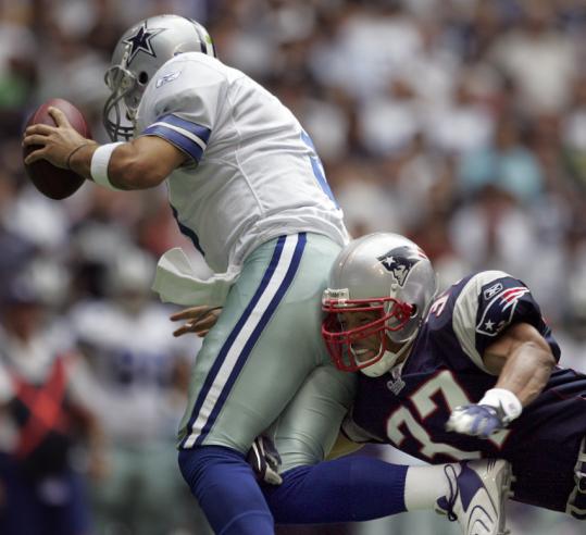 Patriots safety Rodney Harrison has Tony Romo under wraps as he sacks the Cowboys quarterback in the first quarter.