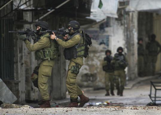 Israeli soldiers made their way through alleyways during a sweep of militants and munitions in Nablus yesterday. Twenty militants were arrested in the four-day army operation.