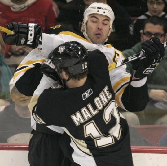 The Penguins' Ryan Malone jolts Bruins captain Zdeno Chara into the boards in the first period.