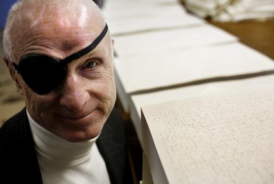 Bill Raeder, retired president of the National Braille Press, among stacks of Braille pages - 539w