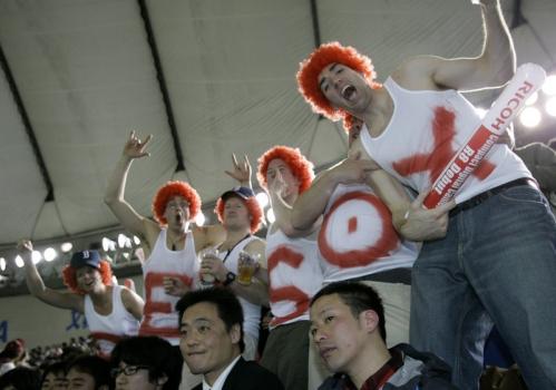 Boston fans cheer during the Major League Baseball regular season opener between the Red Sox and the Oakland Athletics at Tokyo Dome in Tokyo.