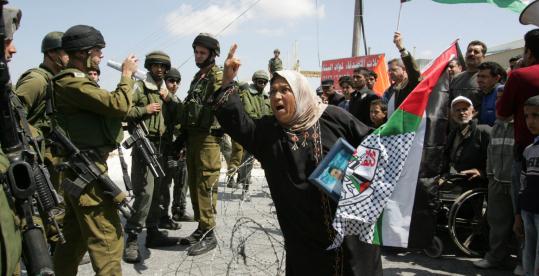 A Palestinian woman gestured as she shouted in the village of Umm Salamunah near the West Bank town of Bethlehem yesterday. Crowds were protesting the construction of an Israeli separation barrier.