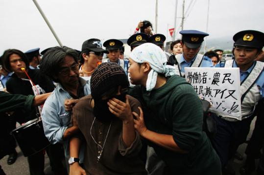 Demonstrators tussled with police yesterday near the G-8 summit in Date, Japan. Some environmentalists faulted the emissions communique, but leaders said the deal would be a tool for negotiatos to achieve further cuts in the future.