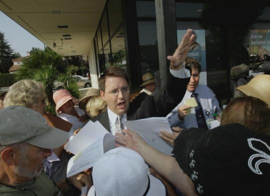 FDIC ombudsman Robert Brown distributed forms as angry depositors swarmed an IndyMac branch in Encino, Calif.