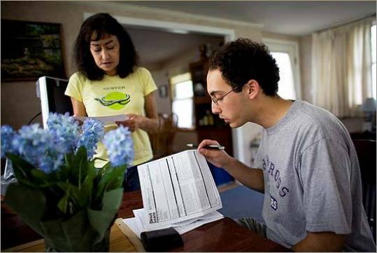 Maria Ferraguto and son Michael, filling out loan forms, do not know how much they will be able to borrow.