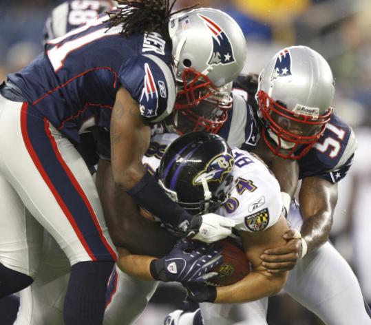 Patriot newcomers Jerod Mayo (51) and Gary Guyton (center) were joined by second-year player Brandon Meriweather for a tackle of the Ravens' Adam Bergen.