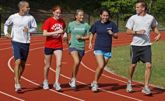 Whitman-Hanson girls' coach Keith Erwin (left) with seniors Caitlin Ryan, Kelci Sullivan, Emily Regan, and assistant coach Brendon O'Leary.