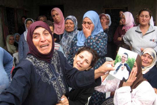 The mother of a Lebanese soldier displayed a picture of her son as she mourned his death outside her house yesterday.