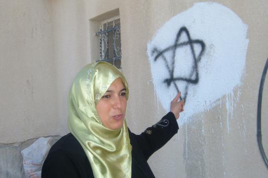 Just hours after a stabbing attack on an Israeli boy in Yitzhar, a group of settlers attacked Nahla Mahmoud's home, uprooting trees and painting Jewish stars on her house in the West Bank.