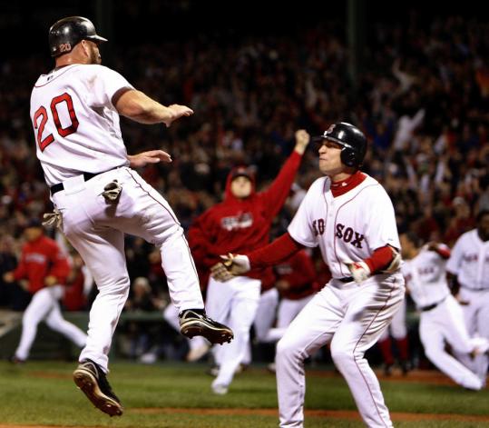 Let's dance: Airborne Kevin Youkilis, who scored the winning run, and Jed Lowrie were front and center in the postgame celebration.