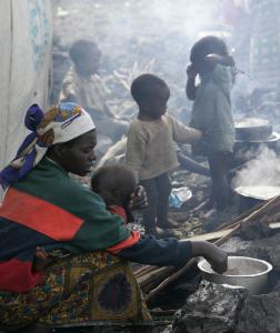 A woman cooked yesterday at a camp for refugees near Goma in eastern Congo. The United Nations is trying to help tens of thousands of civilians displaced by fighting in the country.