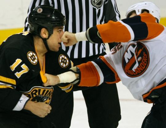Bruins forward Milan Lucic, who has a nose for the action, gets popped in the nose by a left from Islanders defenseman Brendan Witt during their fight in the third period.