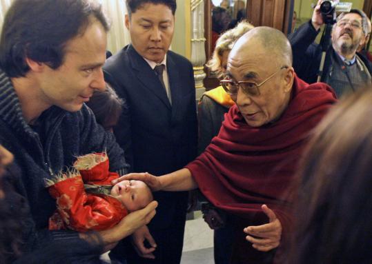 The Dalai Lama blessed a child yesterday upon his arrival in Prague for a meeting with former president Václav Havel. He also had plans to address the Tibet Group in the Czech Parliament.