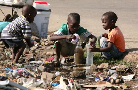 Children collected stagnant water yesterday for use at home in Harare. The collapse of Zimbabwe's health and sanitation systems has created fears of a regional cholera epidemic.