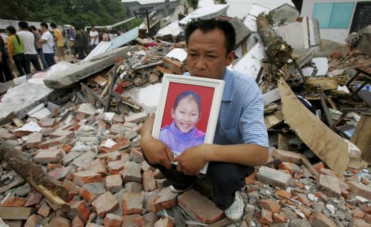 A father held a photo of his daughter, who was killed in the Fuxin No. 2 Primary School in Wufu, in China's Sichuan Province, during the earthquake in May.