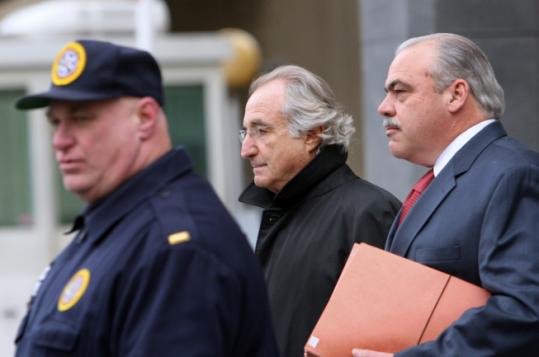 Bernard Madoff is escorted out of federal court in Manhattan yesterday after a bail hearing.