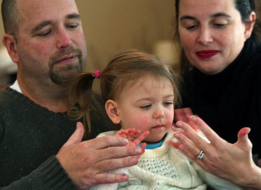 Doug Schmidt and Maria Salomão-Schmidt of Holliston with Olivia, whom they adopted from - 539w