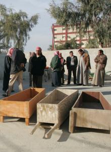 Men gathered in Baqubah on Saturday next to coffins for nine members of an Iraqi family killed by gunmen.