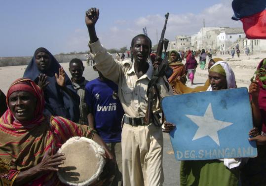People celebrated on the streets of Mogadishu yesterday after moderate Islamist leader Sheikh Sharif Ahmed (at left) was sworn in as Somalia's president. Somali women danced in the streets and antiaircraft missiles were blasted into the air to celebrate Ahmed's election victory.