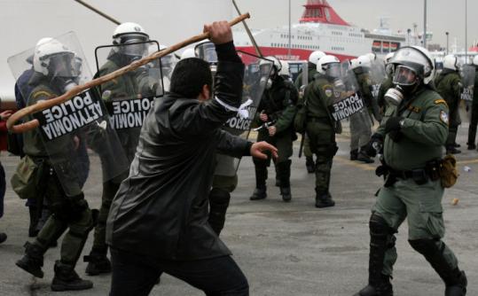 A Greek farmer swung a shepherd's crook at a riot policeman yesterday in the port of Piraeus, near Athens.