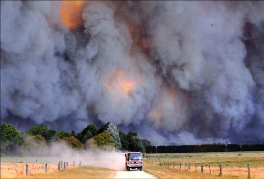 An emergency vehicle raced away from a tower of smoke and fire in the hard-hit Gippsland region of Australia yesterday.