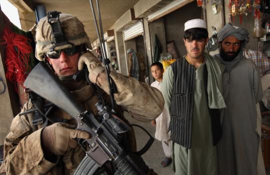 John Moore/Getty ImagesA US Marine on patrol listened to a radio message in a bazaar in Delaram, Afghanistan.