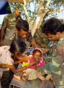 Military personnel tended to a child at a camp in northern Sri Lanka, where people are staying after fleeing the war zone.