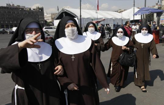 A group of nuns wore surgical masks to protect themselves against swine flu yesterday in Mexico City.