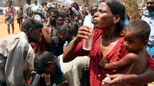 Some of the more than 100,000 that fled the area held by the rebel Tamil Tigers stood in line to receive food and water yesterday in a refugee camp near Manik in northern Sri Lanka.