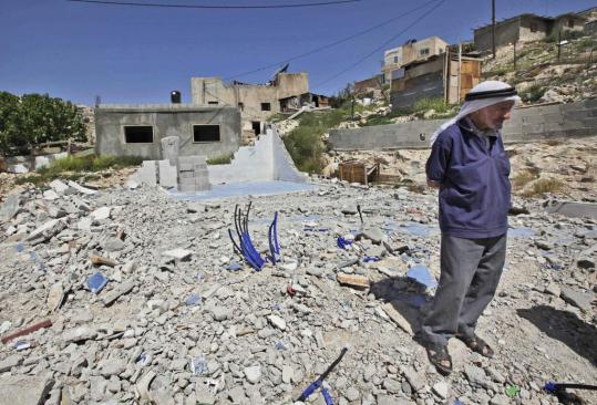 A Palestinian man stands in front a home demolished by Israeli authorities several months ago. A UN agency is calling for a freeze on demolitions in East Jerusalem.
