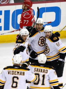 Bruins' Milan Lucic (center) scored first, but the Hurricanes laughed last.