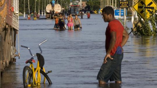 Residents in the northeast state of Maranhao moved along flooded streets yesterday. Thirty-six people have been killed.