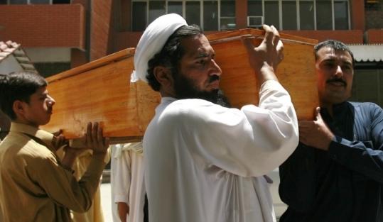 Family members carried remains yesterday of a bombing victim in Peshawar, where a suicide bomber killed 10 people.