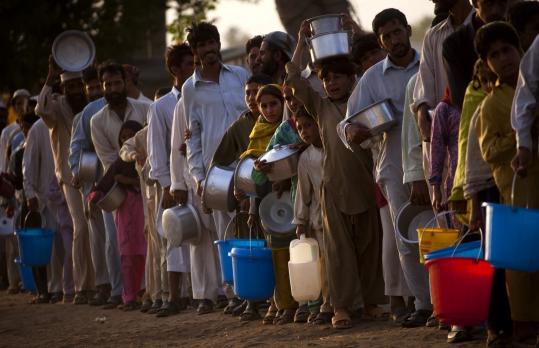 Pakistanis displaced by fighting lined up yesterday for food distribution at Chota Lahore Refugee Camp in Swabi.