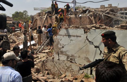 Police and rescuers searched the rubble of a police building after a suicide attack yesterday in Lahore, Pakistan. A suspect was arrested (below). The government said it believes the building was targeted because of Pakistan's campaign against the Taliban.